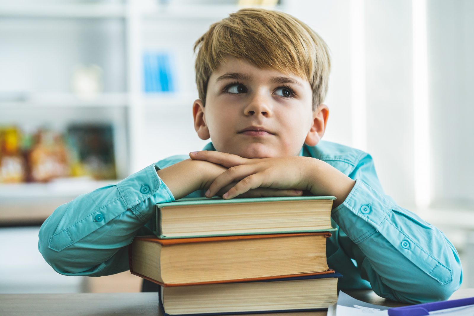 The little boy sitting with books